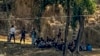 Polisi Perbatasan Myanmar yang mengenakan baju preman beristirahat setelah melarikan diri menyusul serangan oleh tentara etnis Arakan, sementara tentara perbatasan Bangladesh bersiaga di Ghumdhum, Bandarban, Bangladesh, 5 Februari 2024. (Foto: Shafiqur Rahman/AP Photo) 