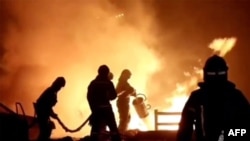 In this image made from video provided by the Russian Emergency Situations Ministry press service, firefighters work to extinguish a fire at a petrol station on a road near Makhachkala, the capital of Dagestan, Russia, on Aug. 14, 2023